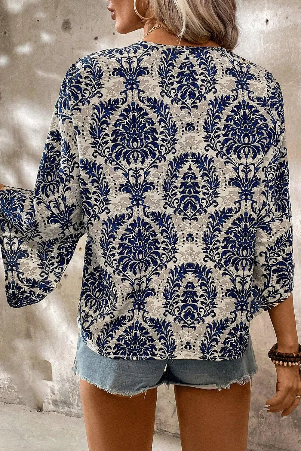 Blusa estampada con cuello en V y mangas tres cuartos