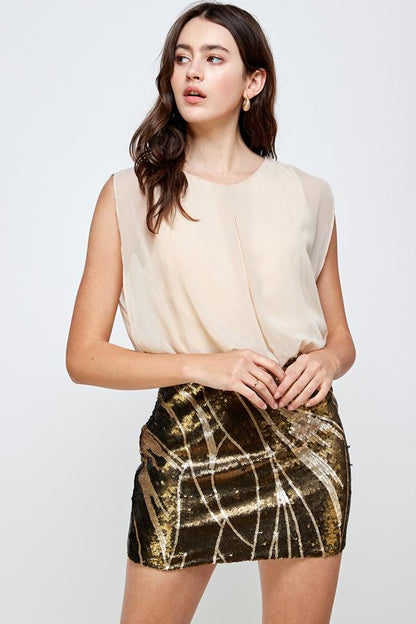 Falda de lentejuelas con vestido blusón sin mangas: un look de fiesta glamuroso