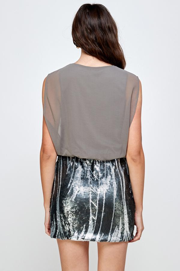 Falda de lentejuelas con vestido blusón sin mangas: un look de fiesta glamuroso
