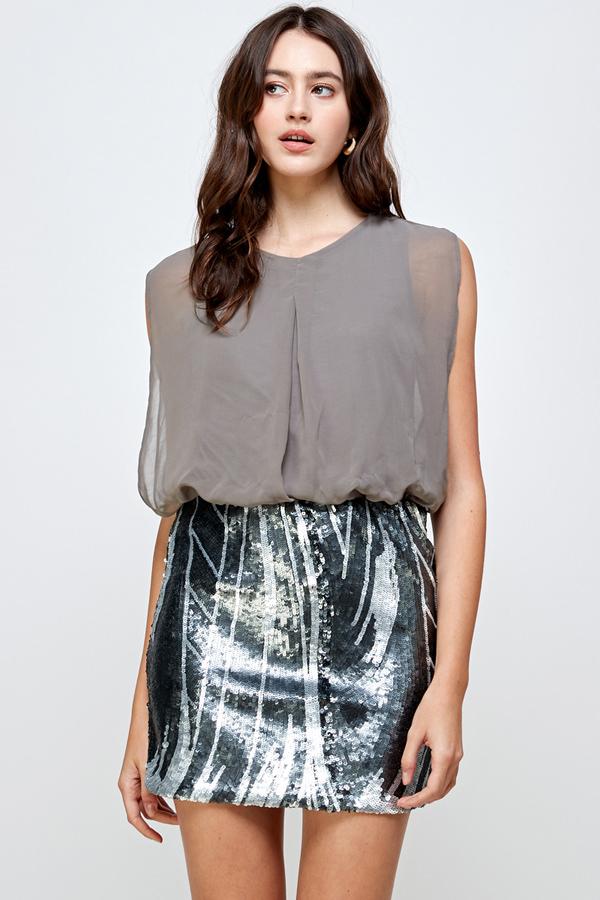 Falda de lentejuelas con vestido blusón sin mangas: un look de fiesta glamuroso