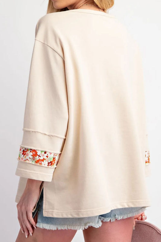 Blusa de cuello redondo con estampado floral y abertura con costuras expuestas